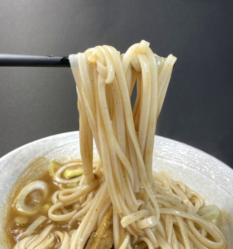 レンジで簡単！カレーうどんの素のうどんを箸でつまむ