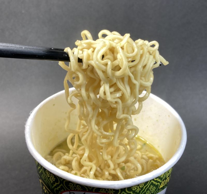 グリーンカレーラーメンをはしでつまむ