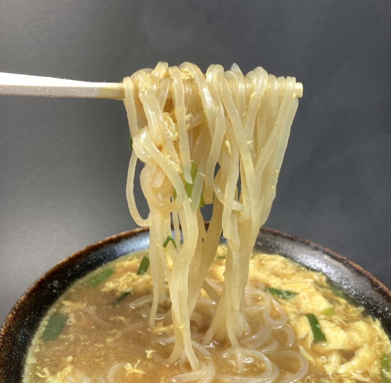 株式会社桝元 宮崎発 生 カレー×辛麺の麺を箸でつまむ