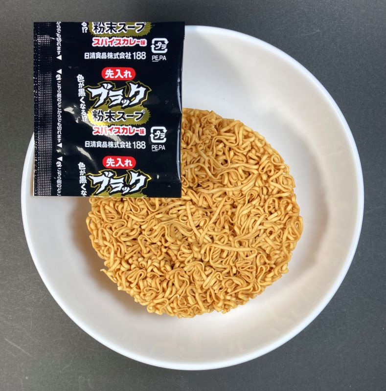 日清食品株式会社 チキンラーメンブラック スパイスカレー味の中身の麺とパウダー