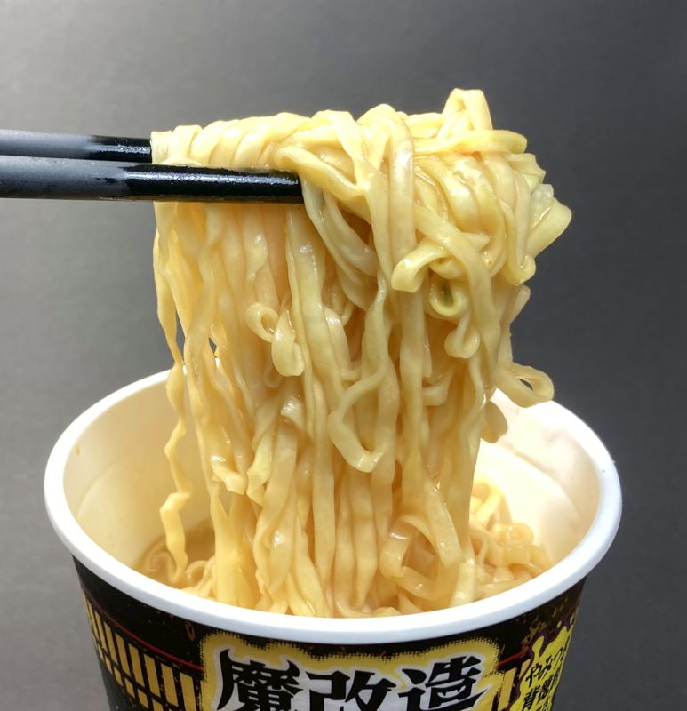 日清食品株式会社 CUP NOODLE CURRY 魔改造 こってりガリマヨカレー!?の麺を箸でつまむ