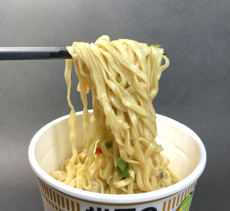 日清食品株式会社_世界のCUPNOODLES_クリーミーグリーンカレーを箸でつまむ写真