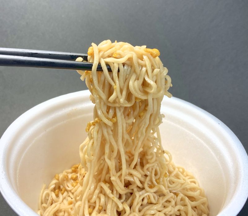 ブタメン焼そばの麺をはしでつまむ