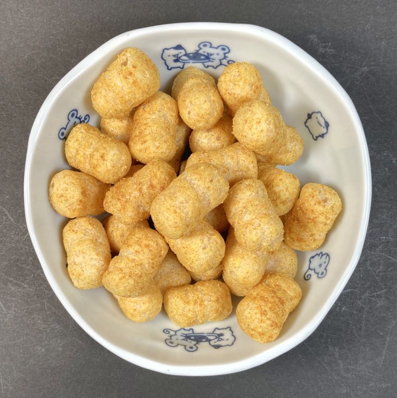 ピュアフォレストフーズ株式会社 発芽玄米スナック こくうまカレー味をお皿に盛る