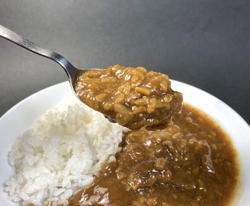 いかめしカレー甘辛口をスプーンですくう