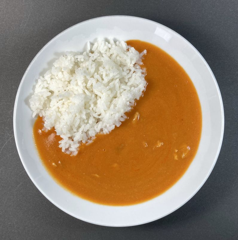 BESTPRICE TOPVALU バターチキンカレーを皿に盛り付ける