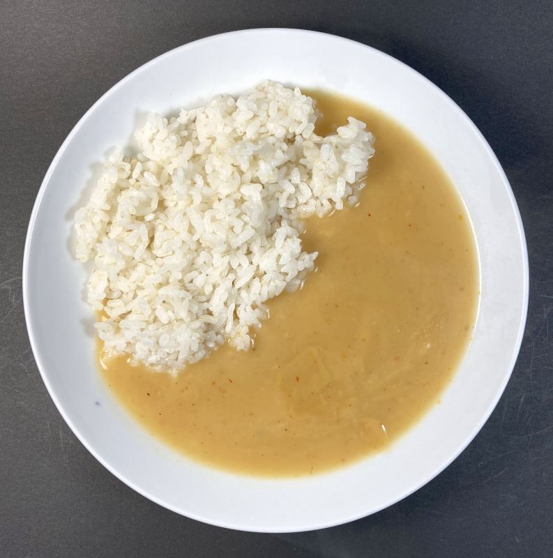 株式会社 mandrillus ココナッツとスパイス香る マンドリルの白いカレーをお皿に盛る