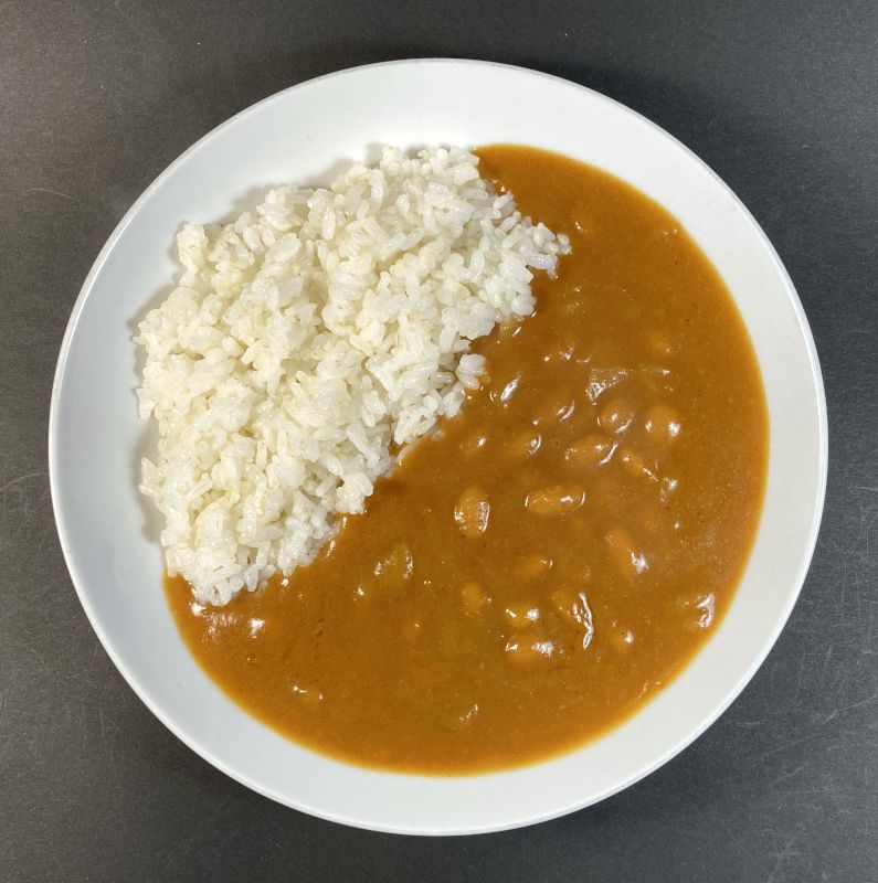 国内産の豆で作ったベジタリアンのための豆カレー中辛をお皿に盛る
